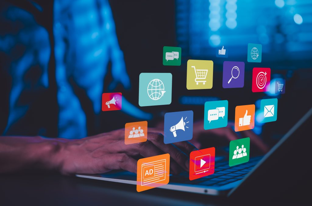 Digital marketing and social media strategy concept. Laptop with icons for advertising, shopping, messaging, targeting, video content, global reach, digital marketing strategy, and online engagement.