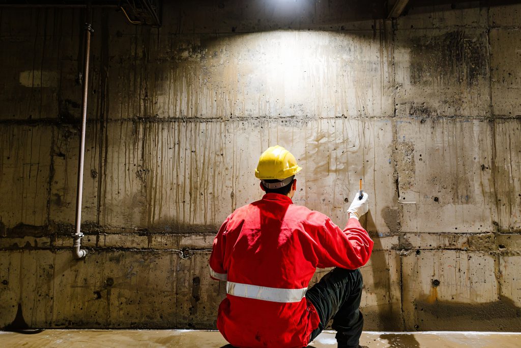 waterproofing application on basement walls, technician working